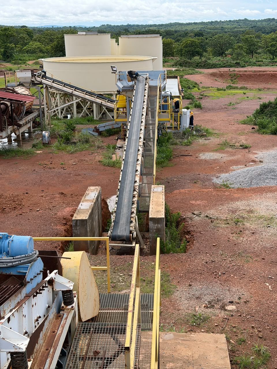 Mineral-processing plant with conveyor and storage tanks on site